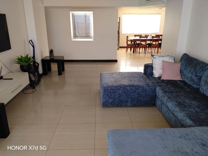 Spacious open-plan living and dining area featuring neutral tiled flooring and a bright, airy layout suitable for modern living.
