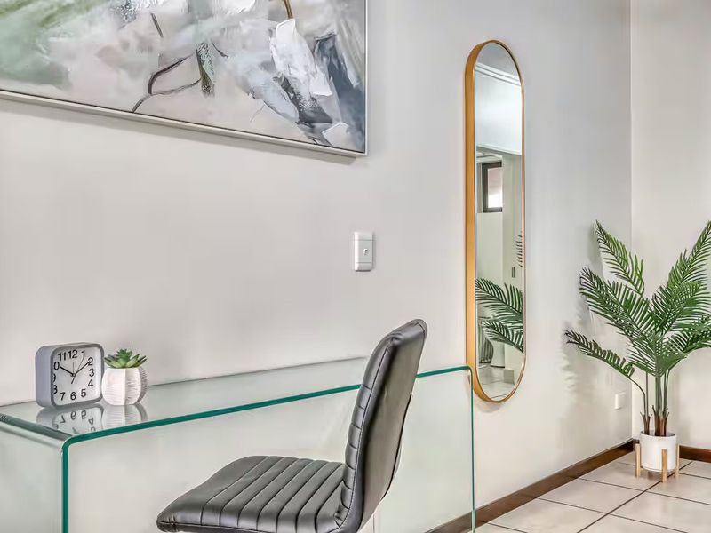 A well-maintained hallway featuring neutral wall finishes and clean tiled flooring, providing a bright and functional transition space within the apartment.
