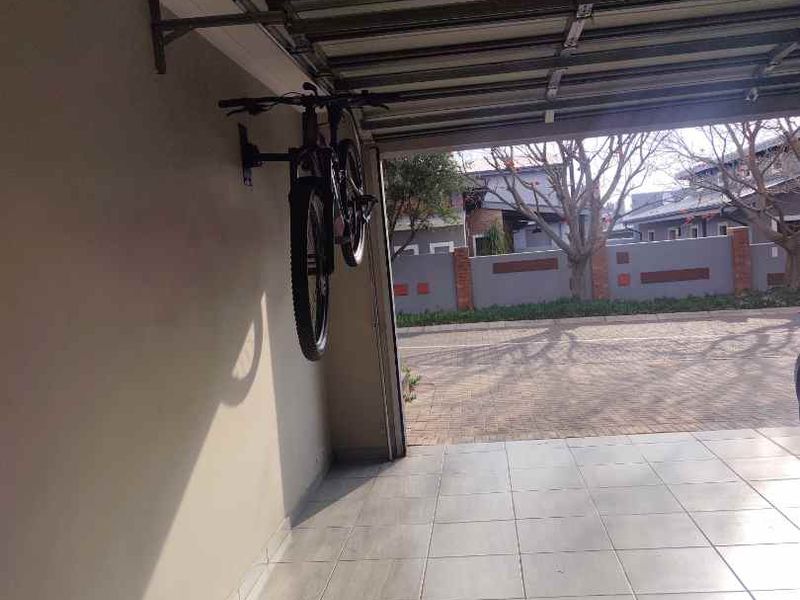 A clean, tiled garage interior featuring a sectional door and neutral wall finishes, providing a functional space for vehicle storage.