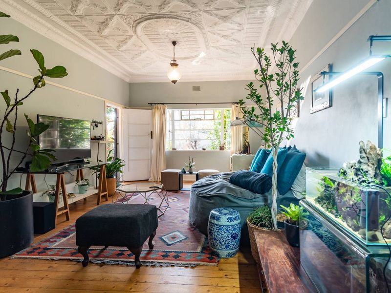 A character-filled living room featuring original ornate pressed metal ceilings, polished hardwood timber flooring, and classic picture rails, offering a warm and inviting atmosphere.