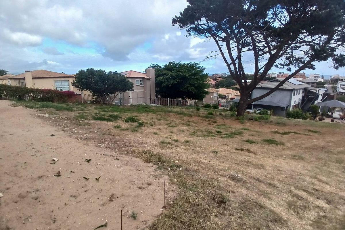 A vacant residential plot featuring established trees, gentle sloping terrain, and surrounding neighborhood views, ideal for future development.