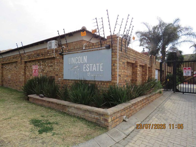 Entrance view of Lincoln Estate featuring a face brick boundary wall, electric fencing, and secure gated access.
