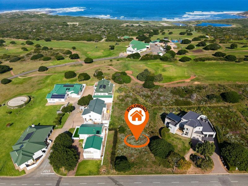 Aerial view of a vacant residential plot situated in a coastal estate, offering proximity to golf course facilities and scenic ocean views.