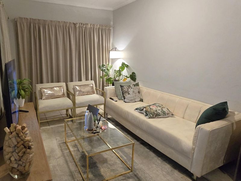 A comfortable living room featuring tiled flooring and neutral wall finishes, providing a functional space for relaxation.