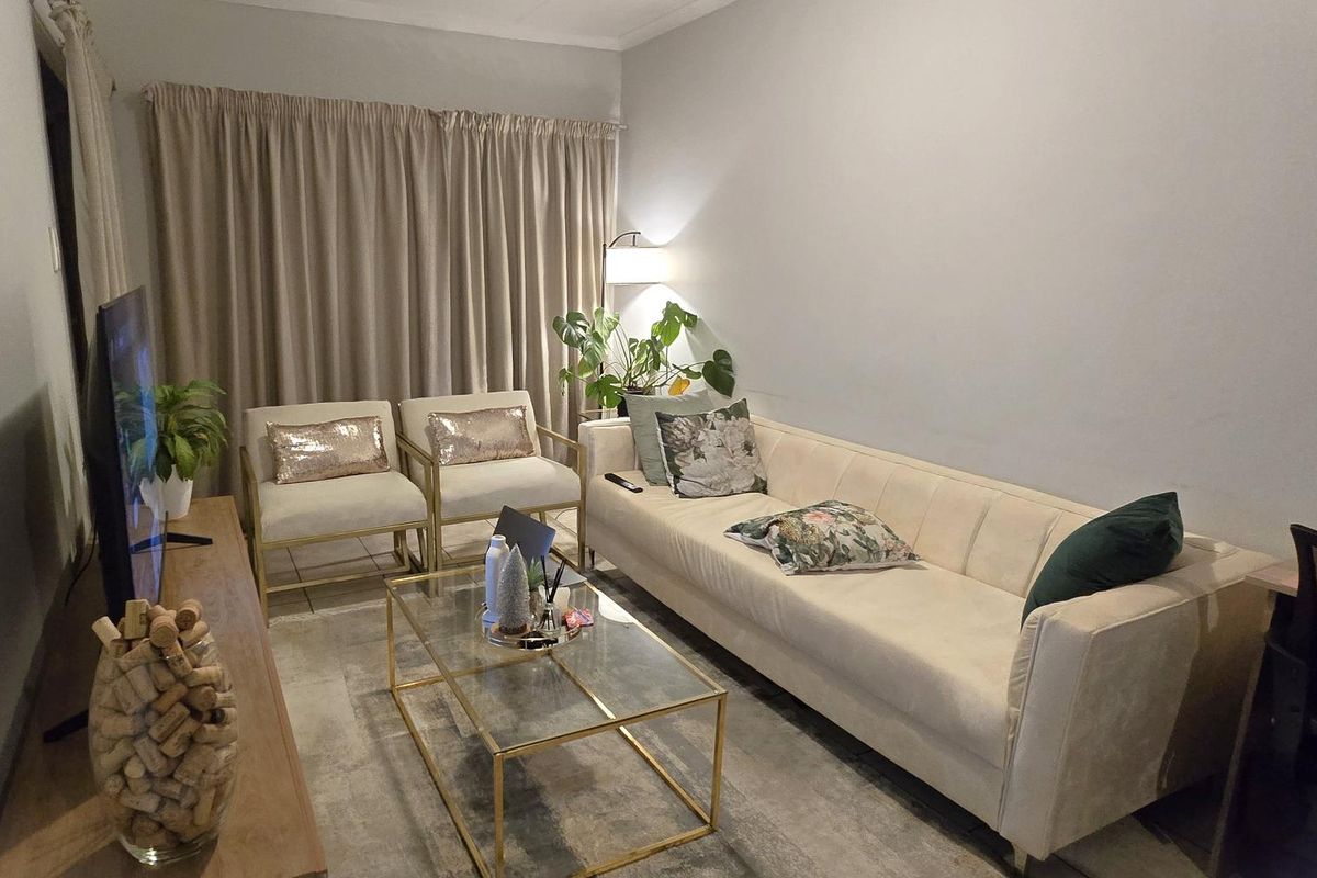 A comfortable living room featuring tiled flooring and neutral wall finishes, providing a functional space for relaxation.