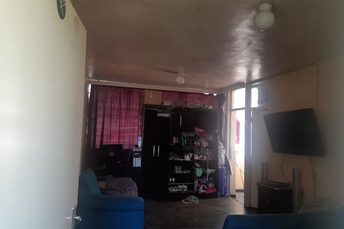 A living room area featuring a ceiling-mounted light fixture and access to an adjacent balcony space.