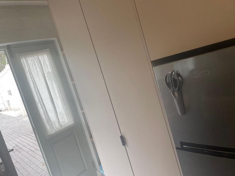 A view of kitchen cabinetry and a glass panel door leading to an outdoor area.