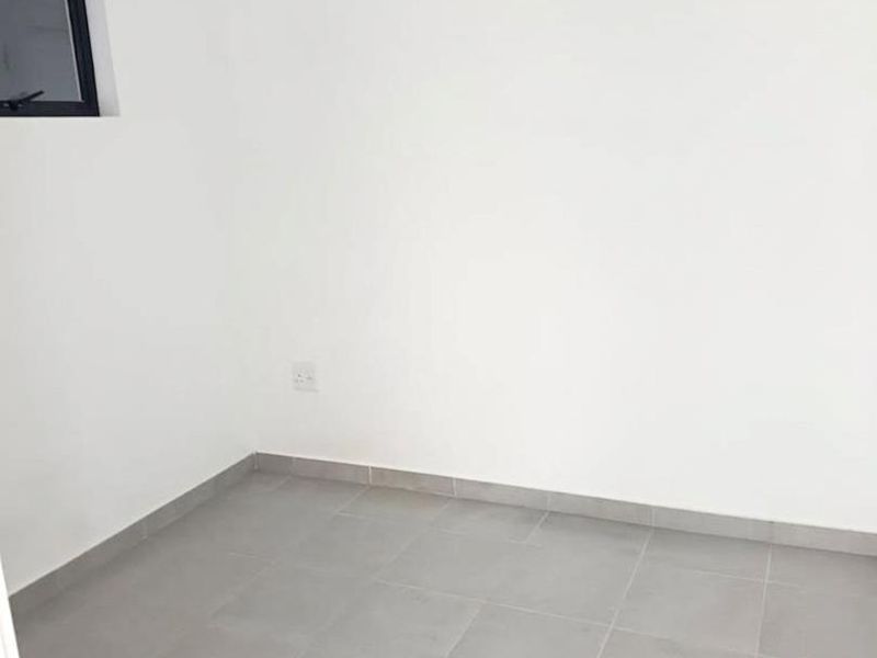 A clean, empty bedroom featuring neutral grey tiled flooring, white walls, and a small window, providing a blank canvas for interior design.