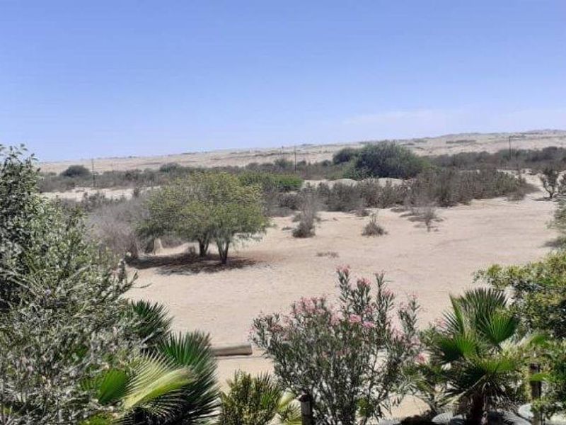 A scenic view overlooking the natural landscape and sandy terrain surrounding the small holding property.