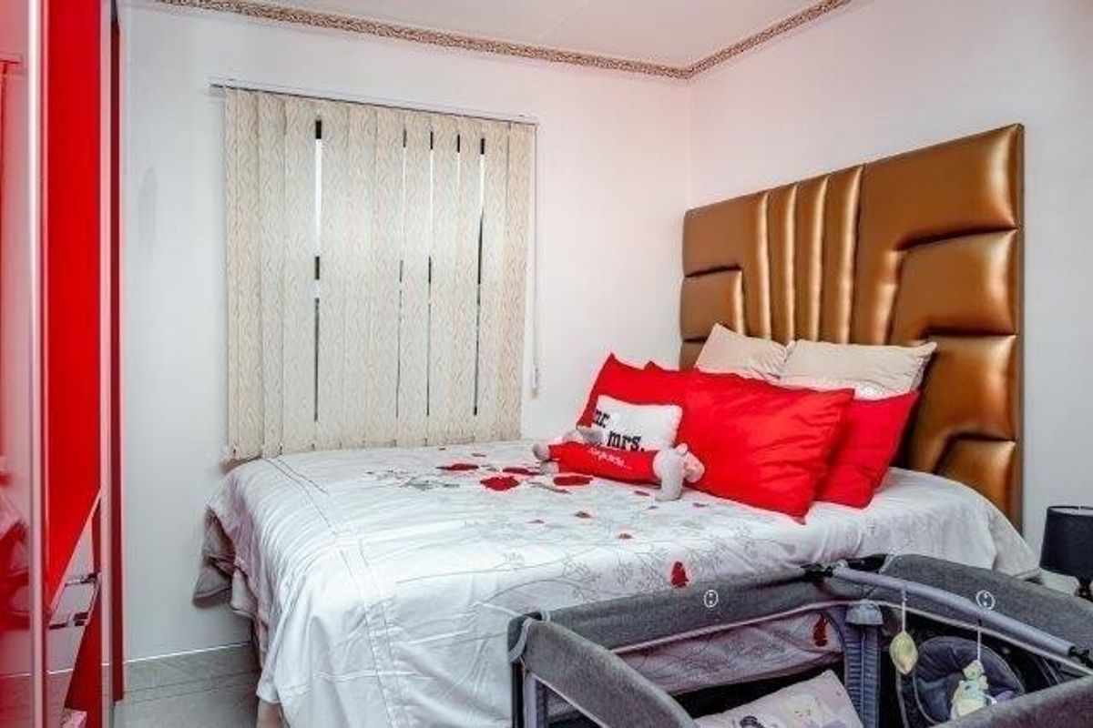 A bedroom featuring a built-in wardrobe, vertical window blinds, and decorative ceiling coving.