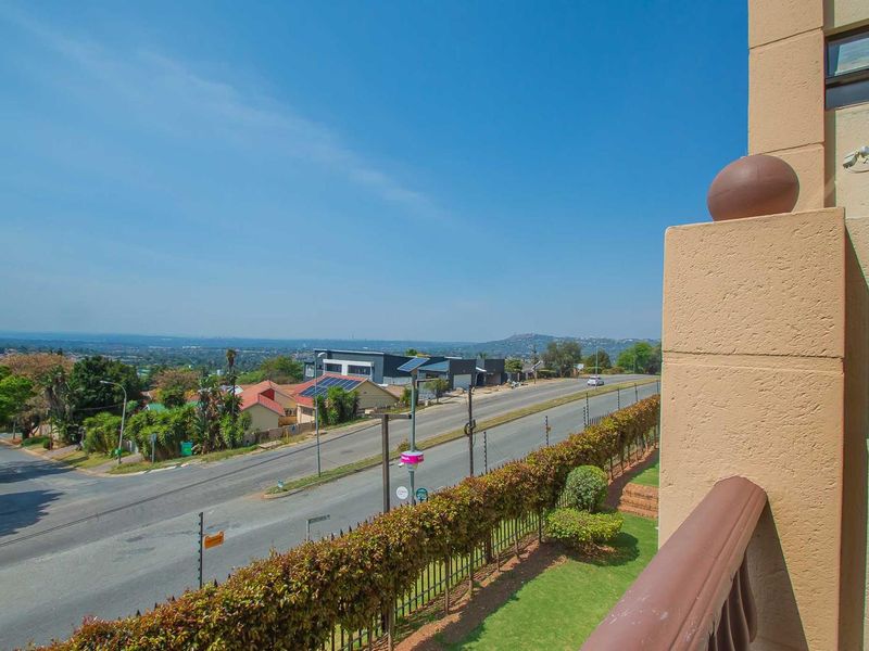 An elevated view overlooking the surrounding suburban neighborhood and street from the apartment balcony.