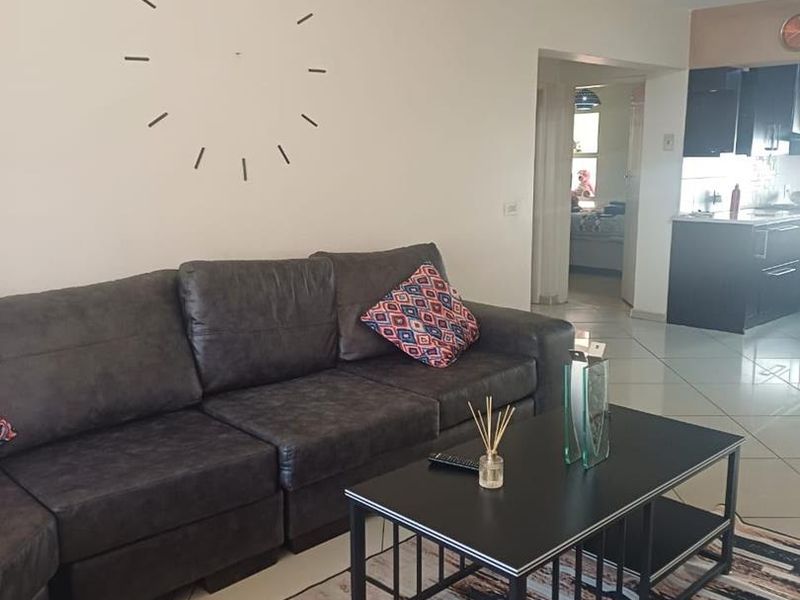 Open plan living area featuring tiled flooring and a view into the adjacent kitchen space.