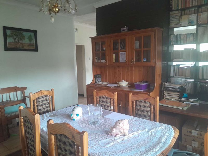 A dining room featuring tiled flooring, coving, and built-in shelving, offering a functional space for family meals.