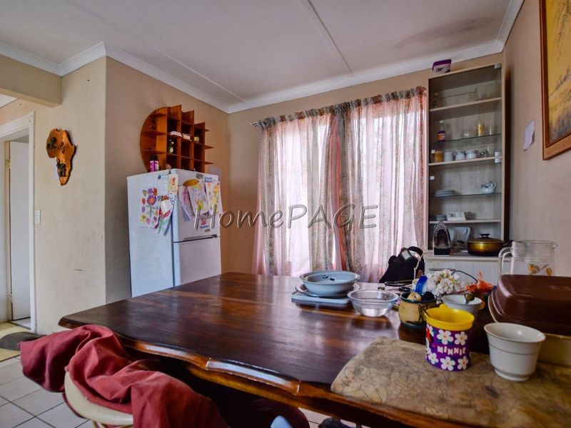 Dining area featuring built-in shelving and coved cornicing, showing signs of ceiling water damage requiring maintenance.