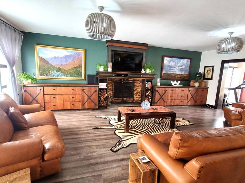 Spacious living room featuring a prominent built-in fireplace, dark wood-look laminate flooring, and a feature wall with integrated cabinetry.
