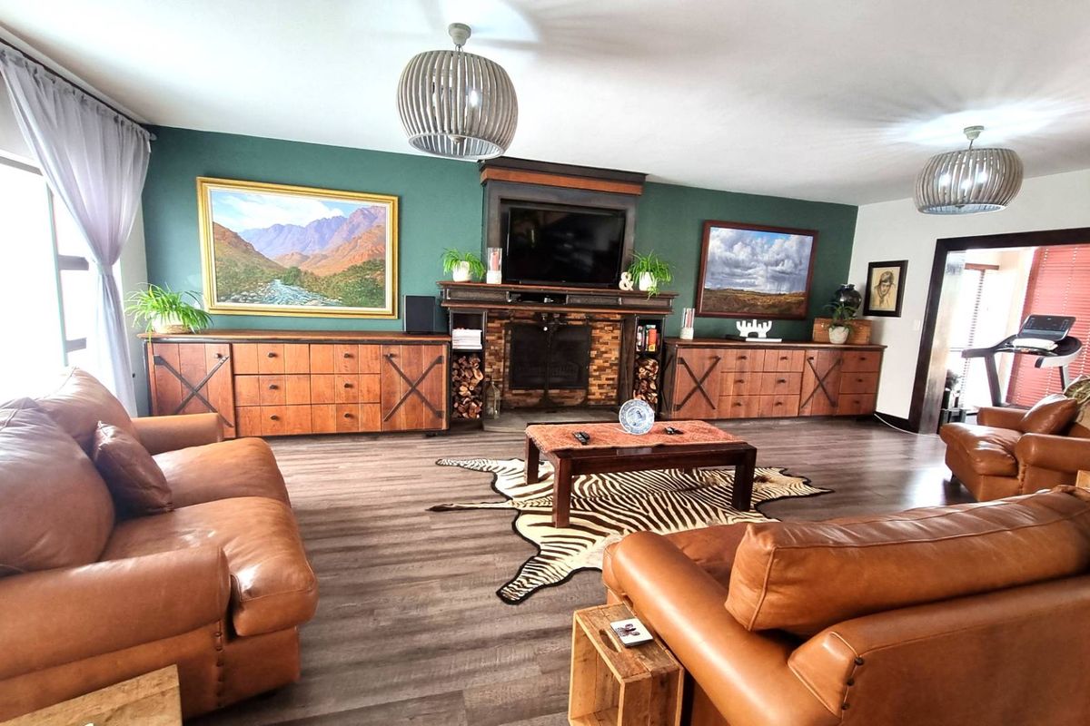 Spacious living room featuring a prominent built-in fireplace, dark wood-look laminate flooring, and a feature wall with integrated cabinetry.