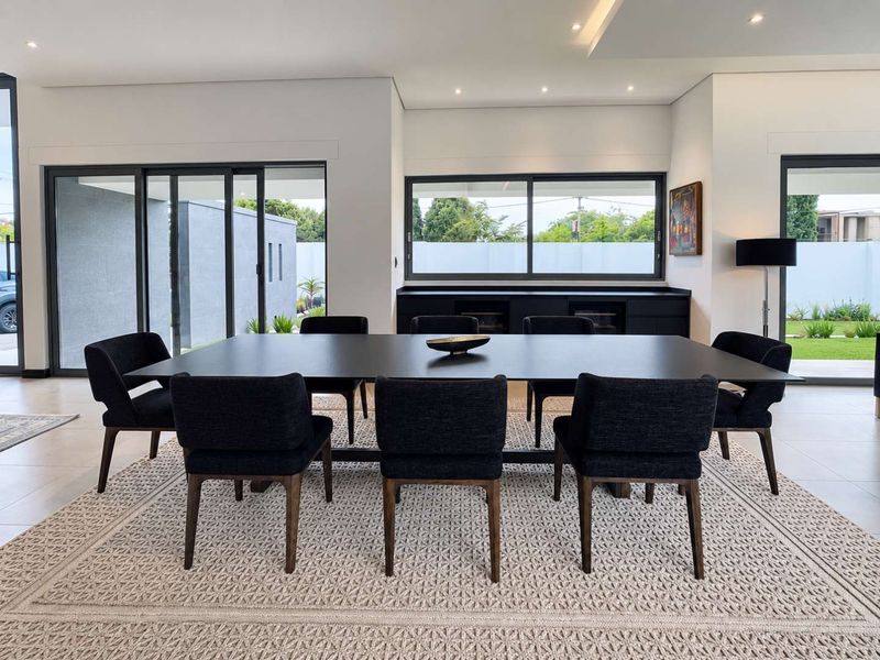 Modern dining room featuring sleek built-in cabinetry, recessed lighting, and large sliding glass doors that provide seamless access to the outdoor patio area.