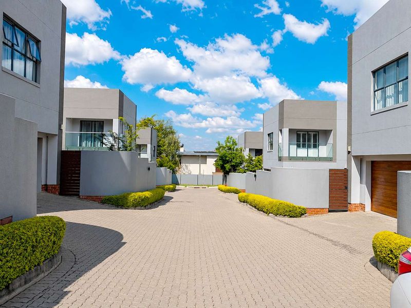 A well-maintained cluster complex driveway featuring modern architectural facades, paved surfaces, and neat landscaping.