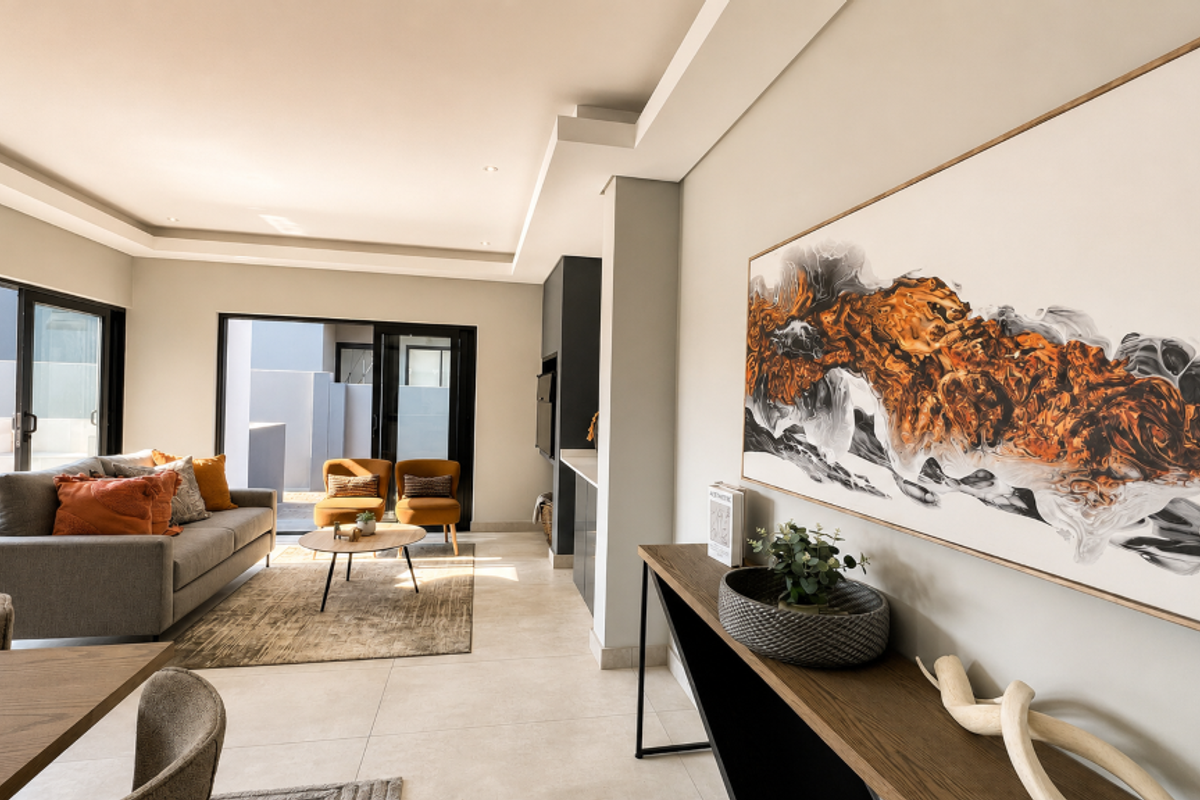 Modern living room featuring tiled flooring, recessed ceiling lighting, and large sliding glass doors providing seamless access to the outdoor patio area.