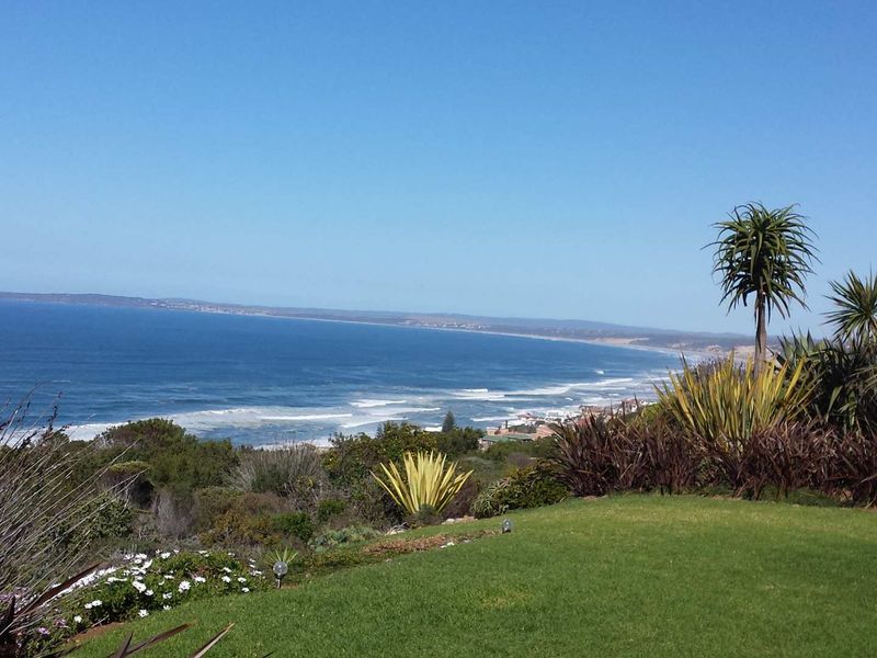 A scenic elevated view overlooking the coastline and ocean, featuring a well-maintained garden in the foreground.