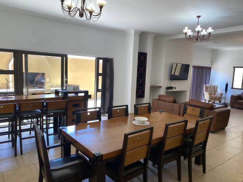Spacious open-plan living and dining area featuring tiled floors, built-in wine storage, and large sliding doors providing seamless access to the outdoor patio.