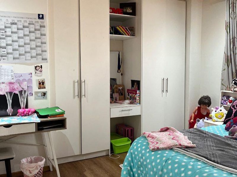 Bedroom featuring built-in wardrobes, warm timber ceiling paneling, and durable laminate flooring.