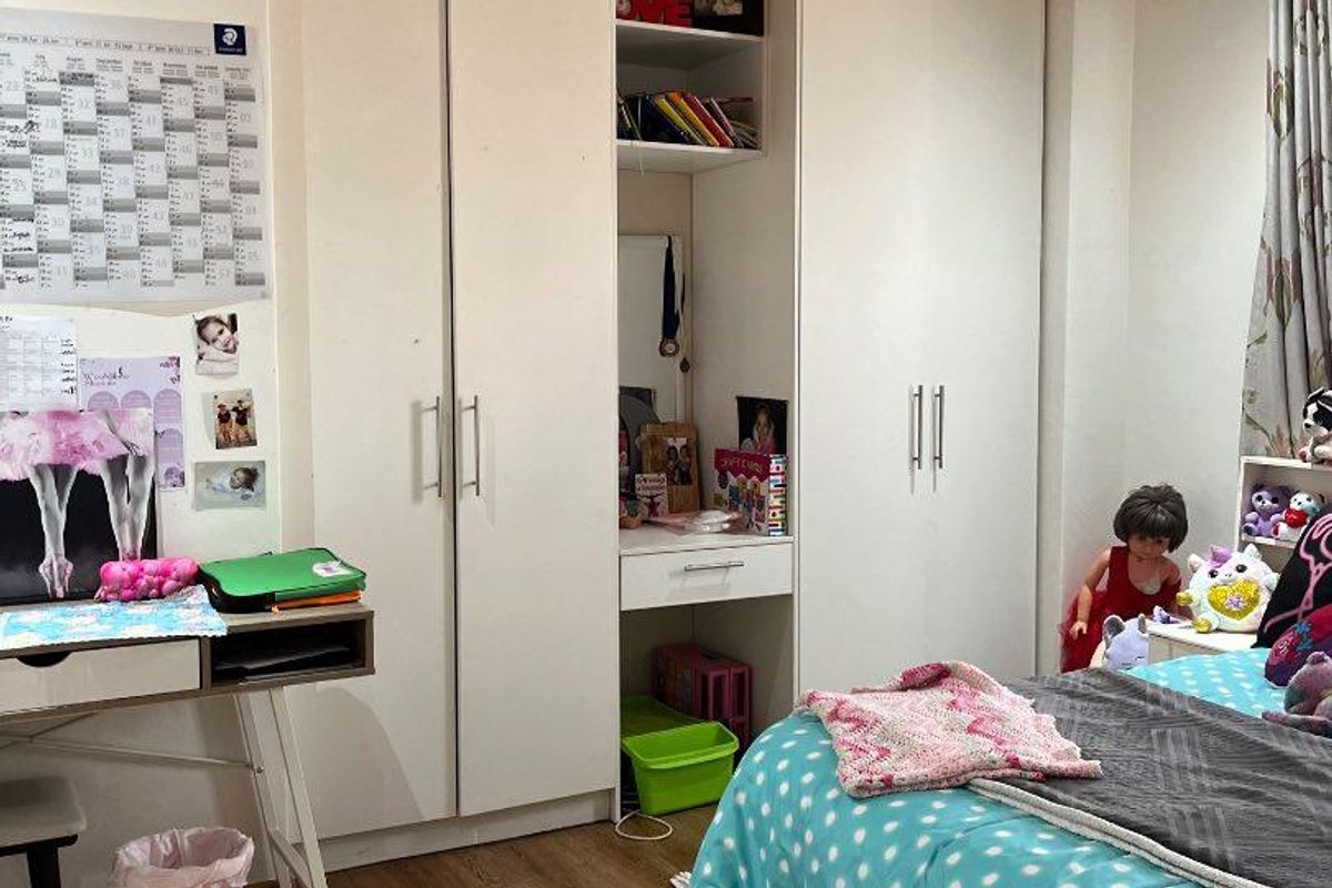 Bedroom featuring built-in wardrobes, warm timber ceiling paneling, and durable laminate flooring.