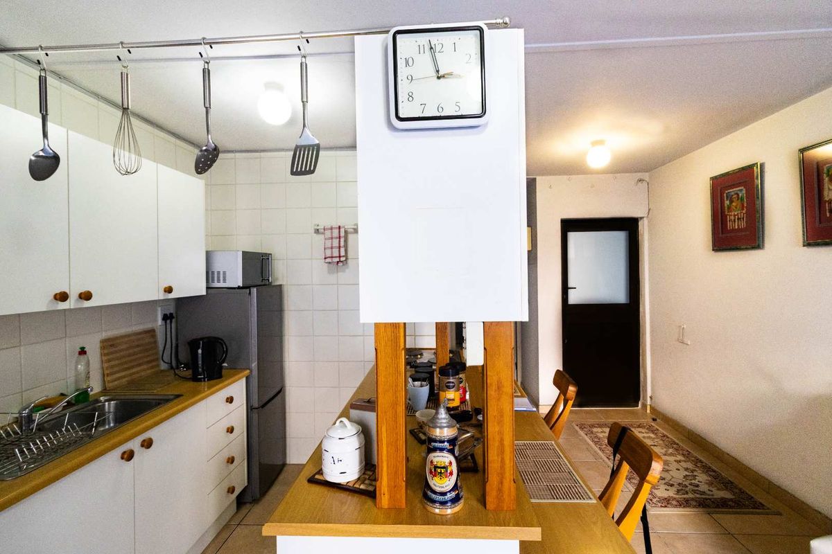 A functional kitchen featuring white cabinetry, laminate countertops, a tiled backsplash, and a central breakfast bar area.
