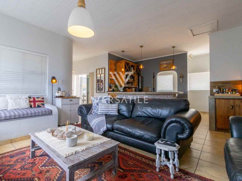 Open plan living area featuring a built-in bench seat, breakfast bar, and tiled flooring, seamlessly connecting to the kitchen space.