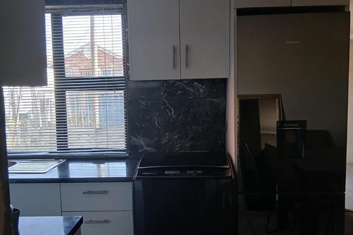 Compact kitchen featuring built-in cabinetry, stone countertops, and tiled backsplash, showing visible signs of ceiling water damage requiring repair.