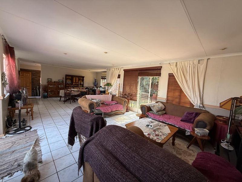 Spacious open-plan living and dining area featuring tiled flooring, recessed lighting, and large sliding glass doors providing access to the exterior.