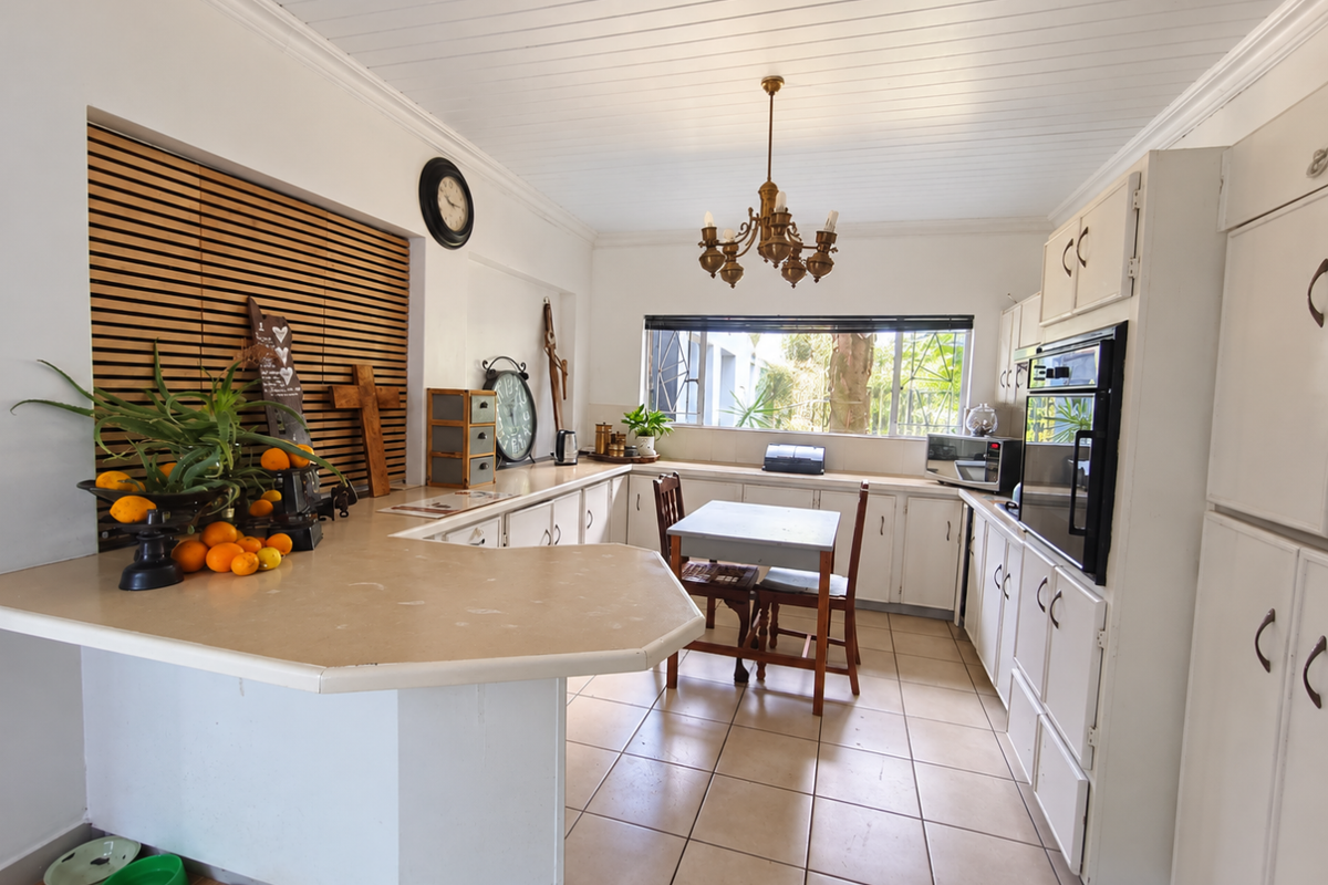 Spacious kitchen featuring ample built-in cabinetry, a breakfast bar, built-in oven, and tiled flooring, offering a functional layout with potential for modern updates.
