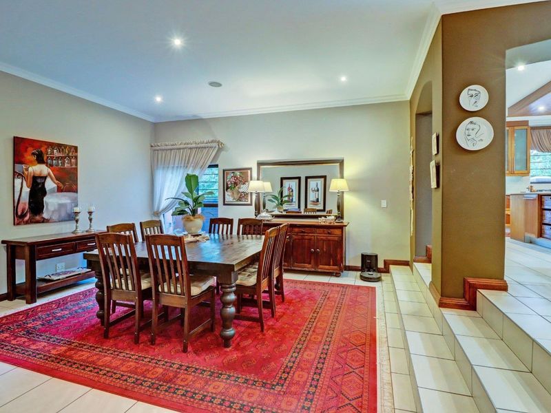 Spacious dining room featuring tiled flooring, recessed lighting, and an open-plan layout with a stepped transition leading into the kitchen area.