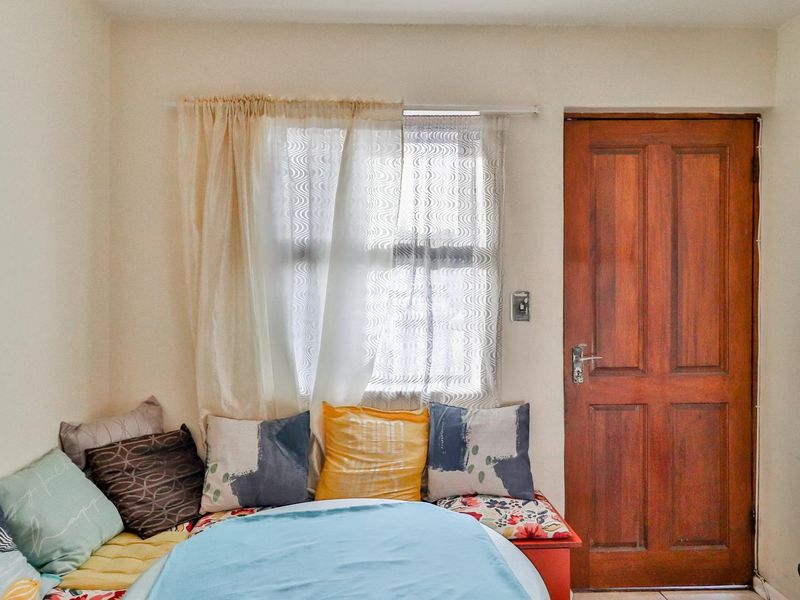 A bedroom featuring a wooden door and a window, providing natural light and access to the space.