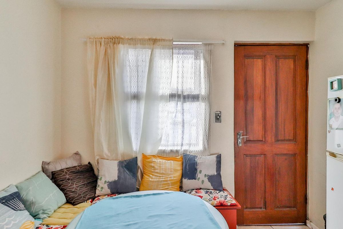 A bedroom featuring a wooden door and a window, providing natural light and access to the space.