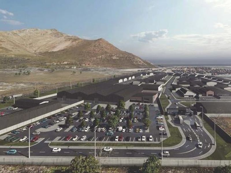 An aerial perspective of a commercial development featuring warehouse structures, extensive paved parking, and integrated access roads within a landscaped site.