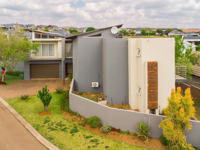 Modern double-story residential property featuring a contemporary architectural design, paved driveway, double garage, and landscaped front garden area.