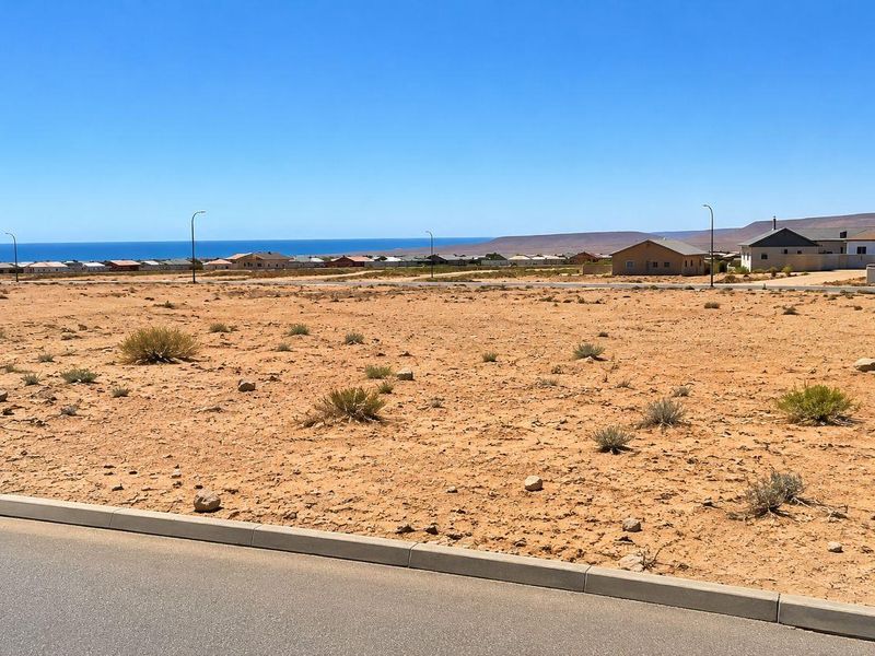 A vacant residential plot featuring a level landscape with distant ocean views and established street infrastructure.