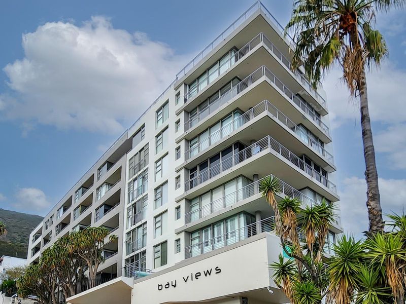 A modern multi-story apartment building featuring clean architectural lines, extensive glass balconies, and large windows offering a contemporary urban aesthetic.