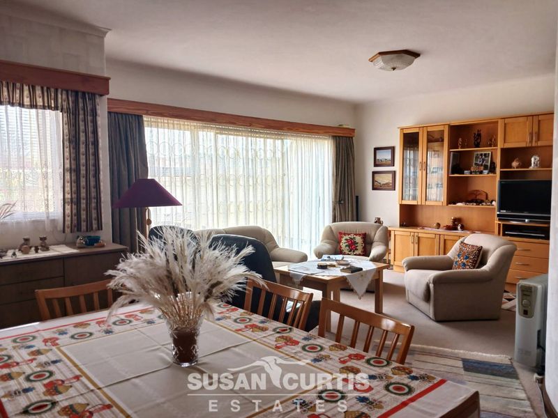 Spacious open-plan living and dining area featuring large sliding glass doors for natural light and integrated built-in cabinetry.