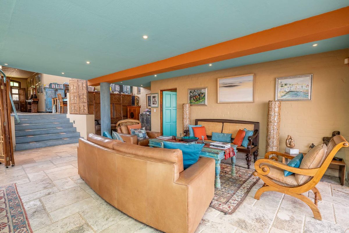 Spacious living area featuring natural stone tile flooring, recessed lighting, and a unique multi-level layout with an exposed structural column.