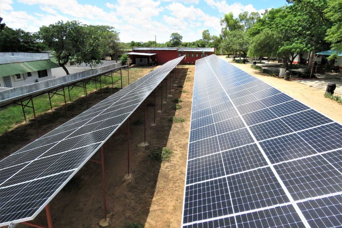 An aerial view of a ground-mounted solar panel array installation situated on the property grounds.