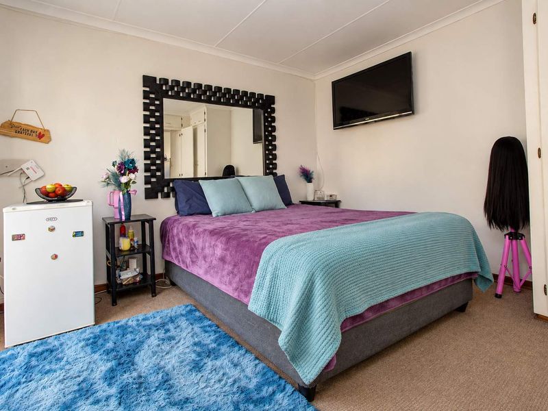 A functional bedroom featuring neutral walls, carpeted flooring, and built-in cupboard storage space.