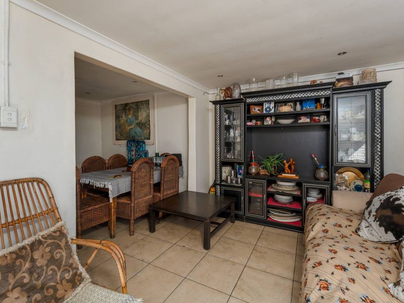 Open-plan living and dining area featuring tiled flooring and recessed lighting, offering a functional layout with potential for modern updates.