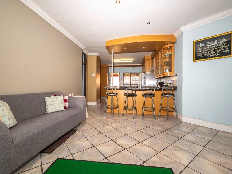 Open plan living area featuring tiled flooring, a breakfast bar with built-in cabinetry, and recessed lighting, creating a functional and connected space.