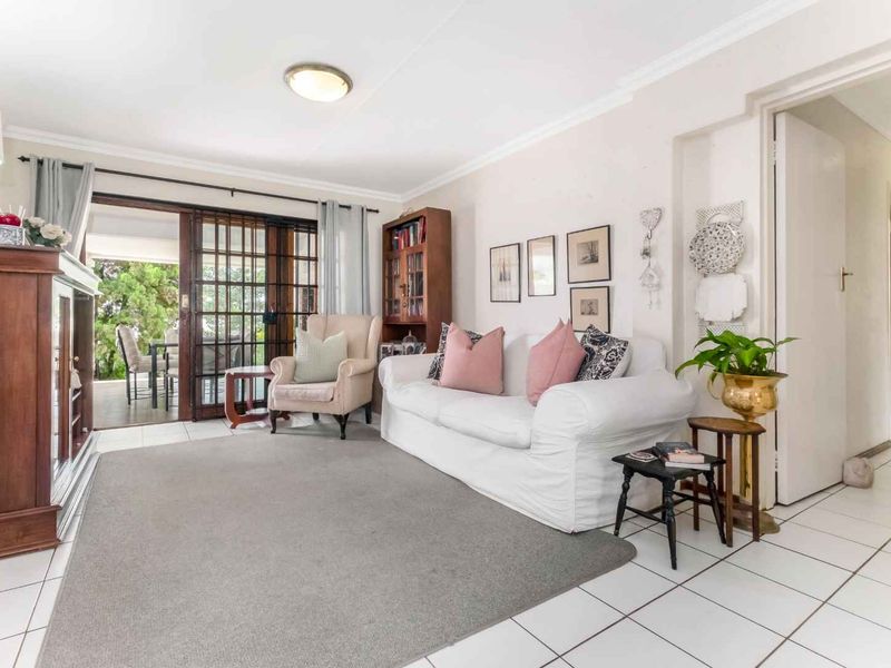A bright living room featuring tiled flooring and sliding glass doors that provide direct access to an outdoor patio area.