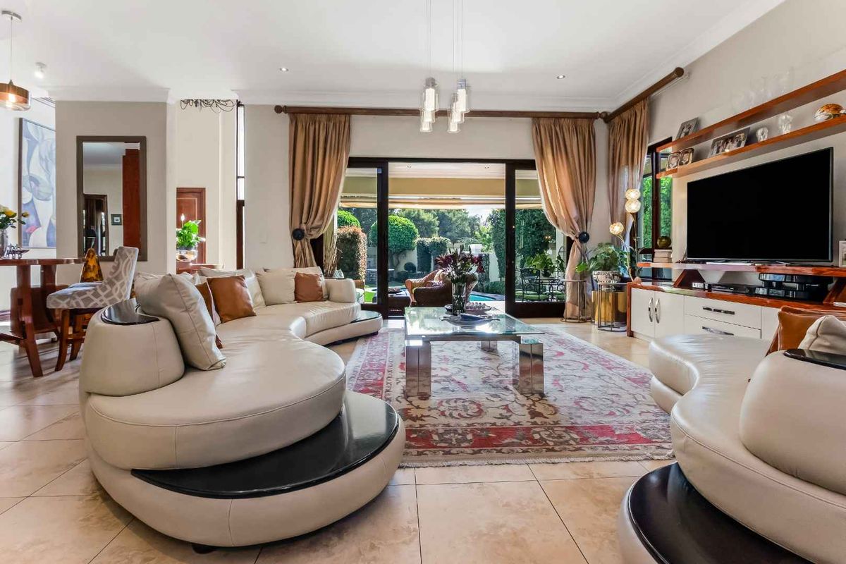 Spacious living room featuring tiled flooring, built-in cabinetry, and large sliding glass doors providing seamless access to the outdoor patio and garden area.