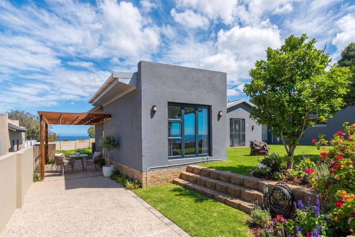A well-maintained rear exterior featuring a modern grey facade, timber pergola over a paved patio, and a landscaped garden with stone retaining walls.