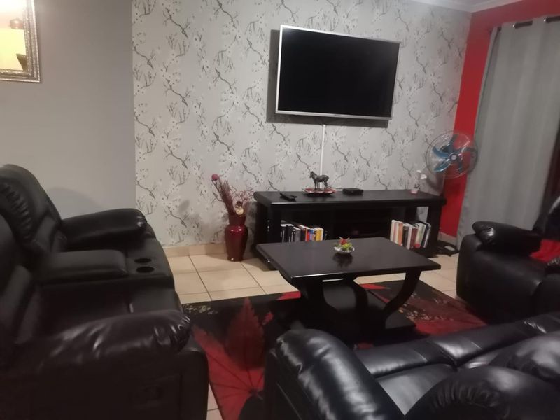 A living room featuring tiled flooring and a decorative feature wall, providing a functional space for relaxation and entertainment.