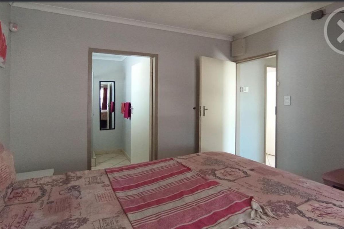 A bedroom featuring neutral wall finishes, coved ceilings, and direct access to an adjoining bathroom area.